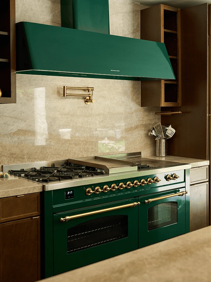 Luxury kitchen with green stove and matching range hood against beige marble backsplash.